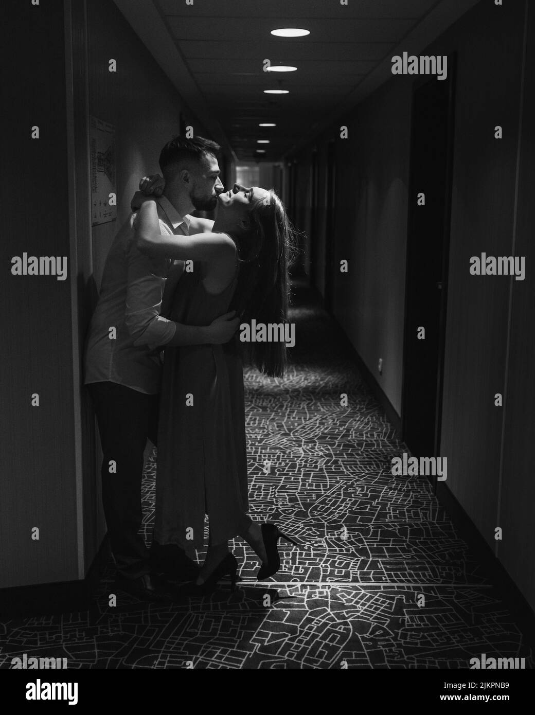 Couple amoureux debout et embrassant dans le couloir de l'hôtel Banque D'Images