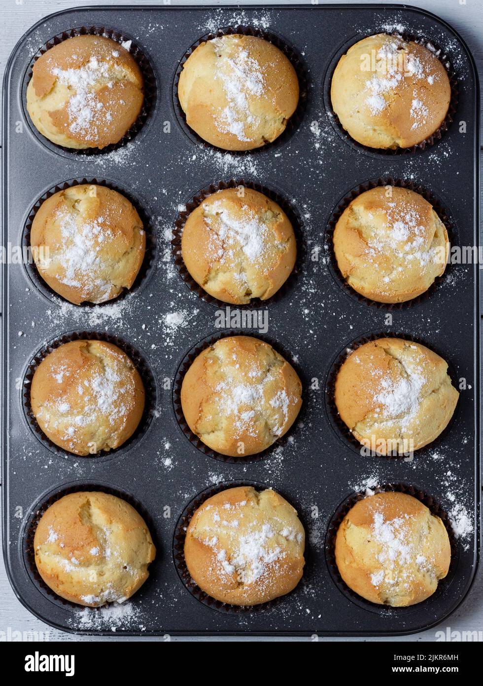 Gâteau maison fraîchement cuit dans un moule à muffins avec doublure en papier. Banque D'Images