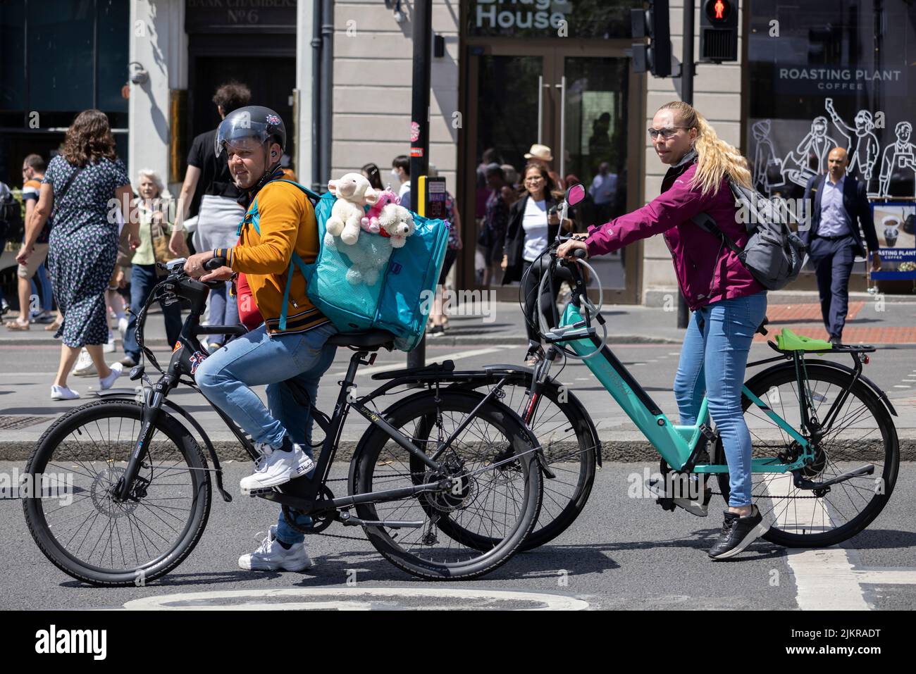 UBER cycliste avec des passagers à ours en peluche qui attendent au feu de circulation à côté d'un autre cycliste, London Bridge, City of London, Angleterre, Royaume-Uni Banque D'Images