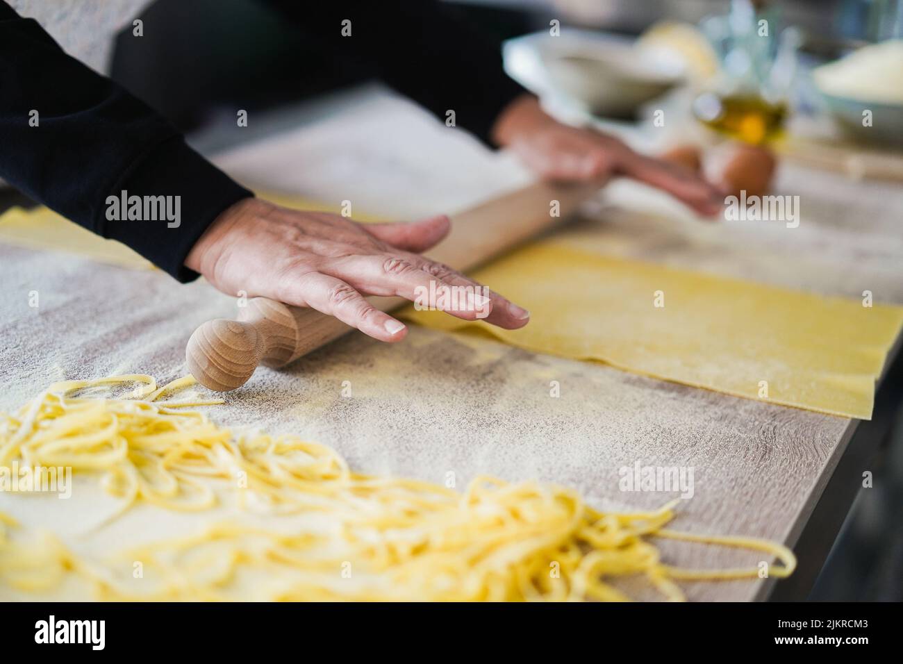 Femme préparant de la pâte pour les raviolis à l'intérieur de l'usine de pâtes - attention douce sur les doigts Banque D'Images