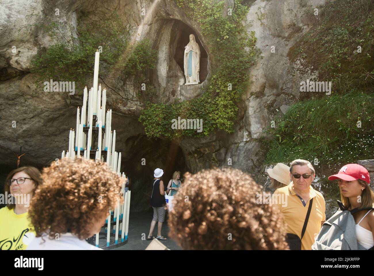 Personnes rassemblées à la Grotte de Massabielle/Grotte des apparitions au Sanctuaire de notre-Dame de Lourdes, pèlerinage. (Statue de la Vierge Marie à Grotto) Banque D'Images
