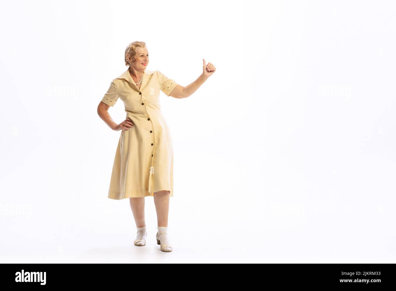 Portrait d'une belle femme âgée en tenue rétro de style vintage posant isolée sur fond blanc. Concept de beauté, vieille génération, mode Banque D'Images