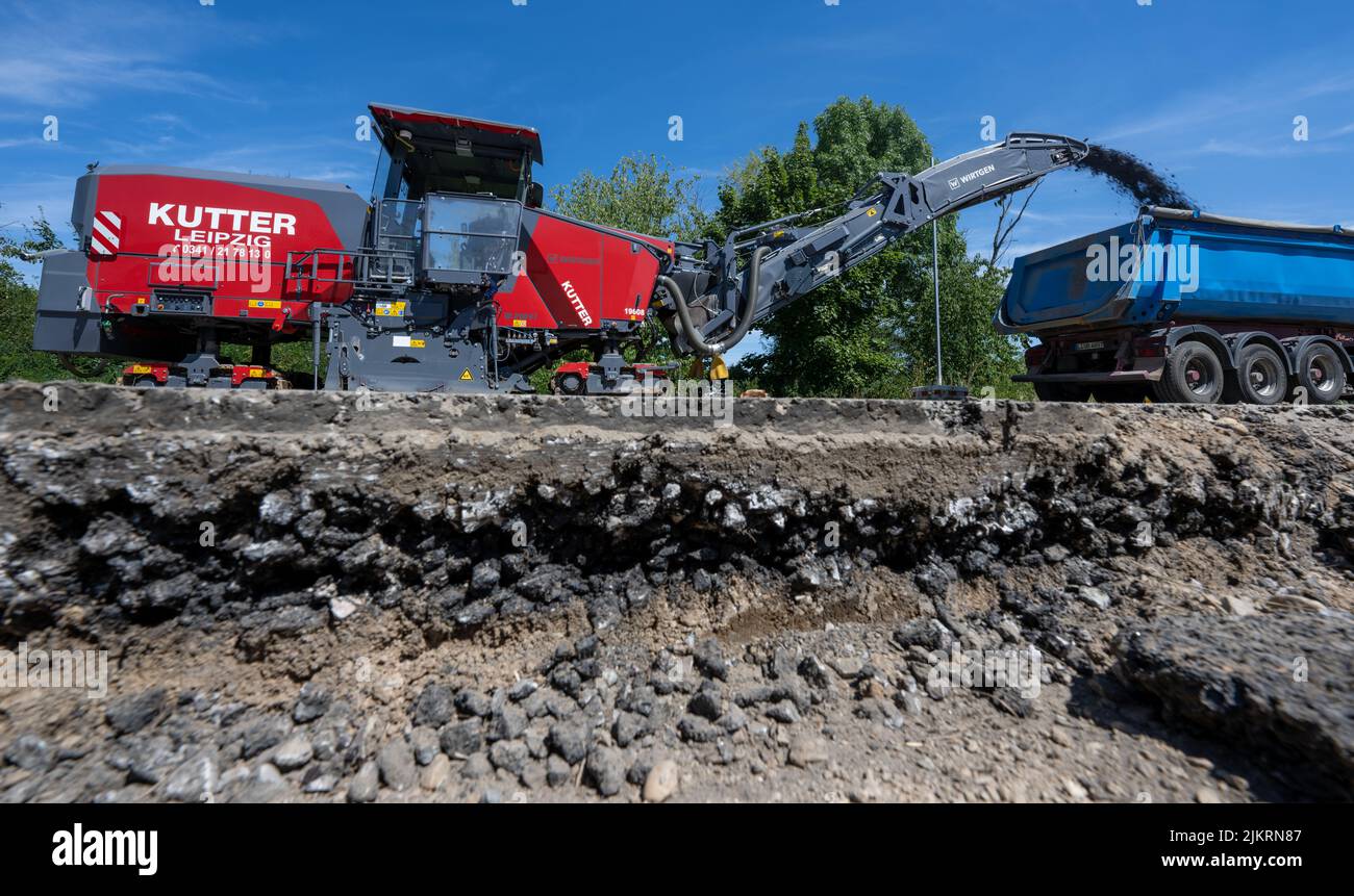 Espenhain, Allemagne. 03rd août 2022. Travaux de déconstruction du B95 sur un chantier de construction à Espenhain. Alors que l'expansion de la dernière section du A72 continue, le B95 autour d'Espenhain est démantelé. Une piste cyclable est actuellement en cours de construction entre Borna et Rötha, en utilisant en grande partie les voies existantes de l'ancienne B95 comme base. Les travaux sur la pièce maîtresse se poursuivront jusqu'à la mi-octobre. Ensuite, l'ancienne autoroute fédérale très fréquentée deviendra la route nationale 242 avec des bandes vertes bordées et de l'espace pour les piétons et les cyclistes. Credit: Hendrik Schmidt/dpa/Alay Live News Banque D'Images