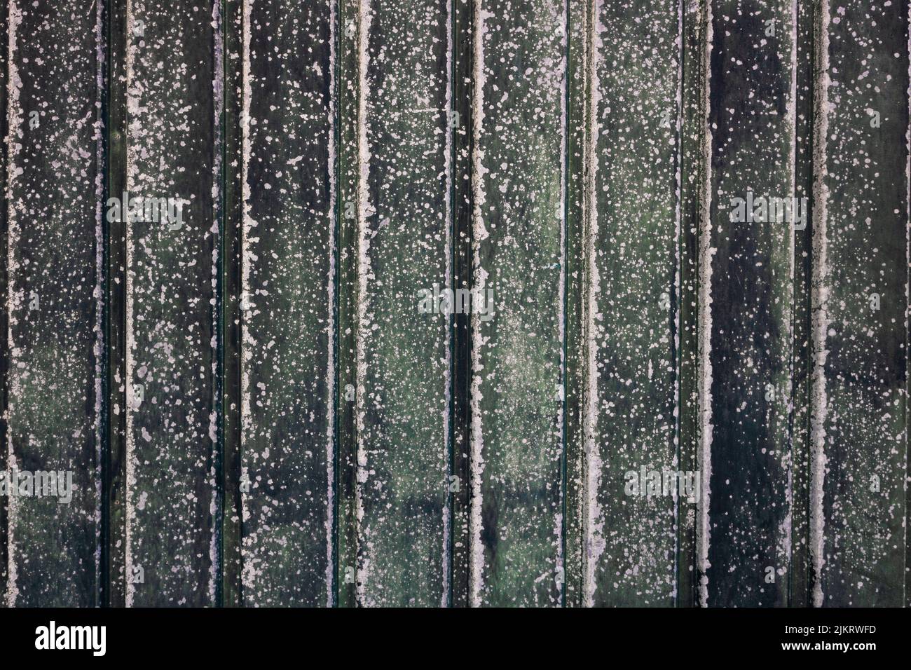 Texture métallique ancienne dans des tons verts décolorés avec motif de bandes verticales et peinture fissurée et abîmé. Arrière-plan abstrait de style vintage Banque D'Images