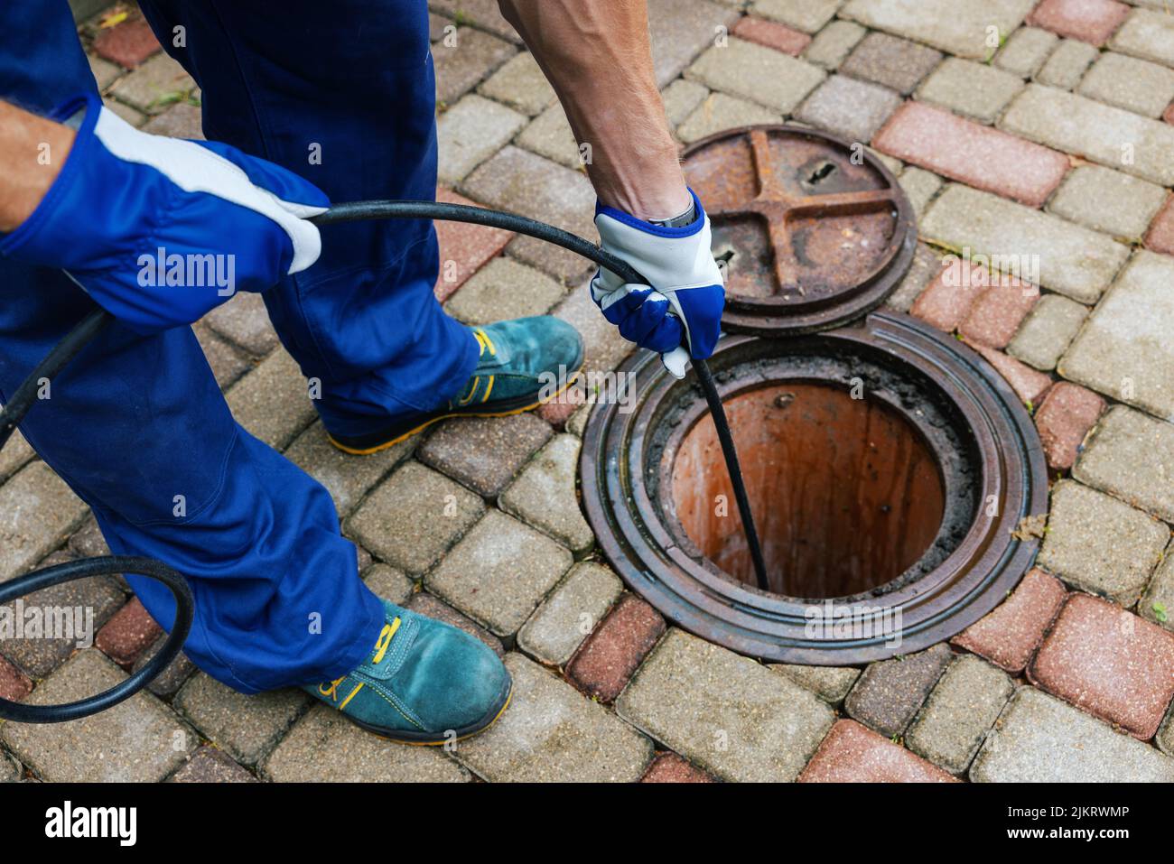 service de nettoyage des égouts - l'employé nettoie une évacuation obstruée à l'aide d'un jet hydro Banque D'Images