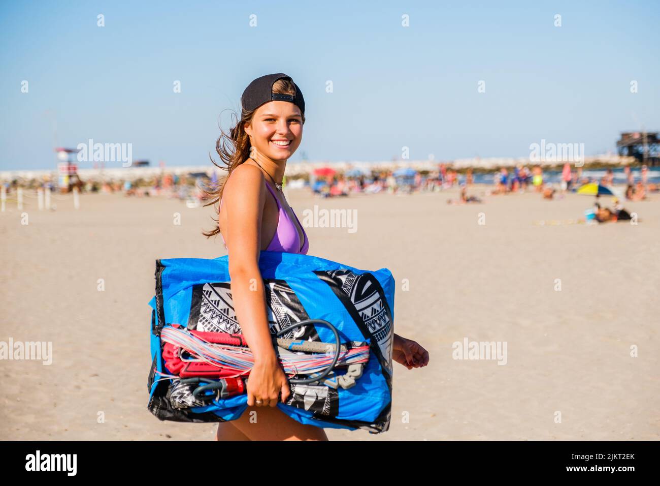 Belle femme kitesurfer prépare le cerf-volant sur la plage et portant l'équipement de kitesurf - concept de femme sportive et d'activité sportive d'été Banque D'Images