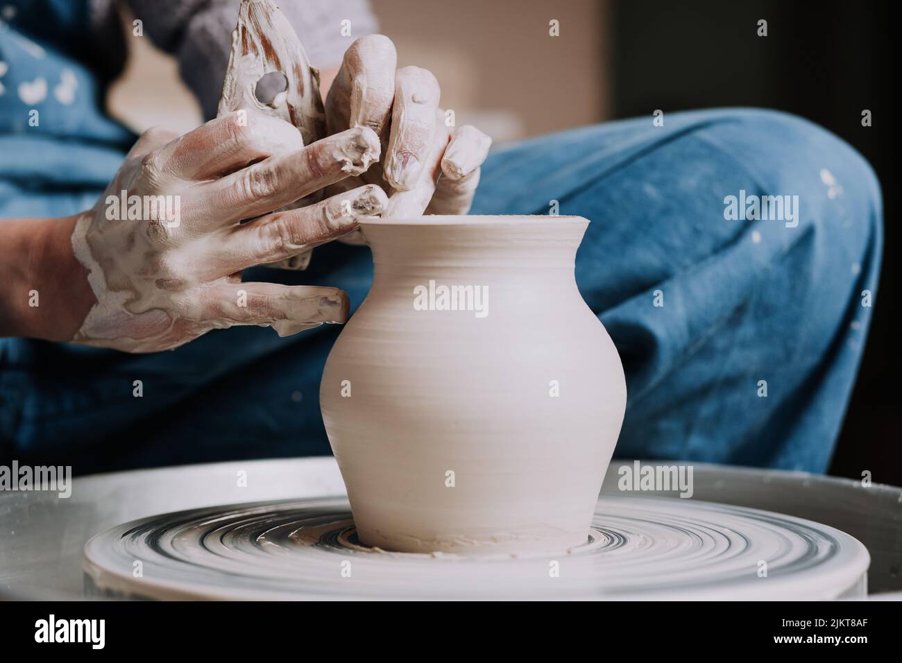 Gros plan sur les mains de femme créant un vase en céramique fait main dans une poterie. Atelier de création. Banque D'Images