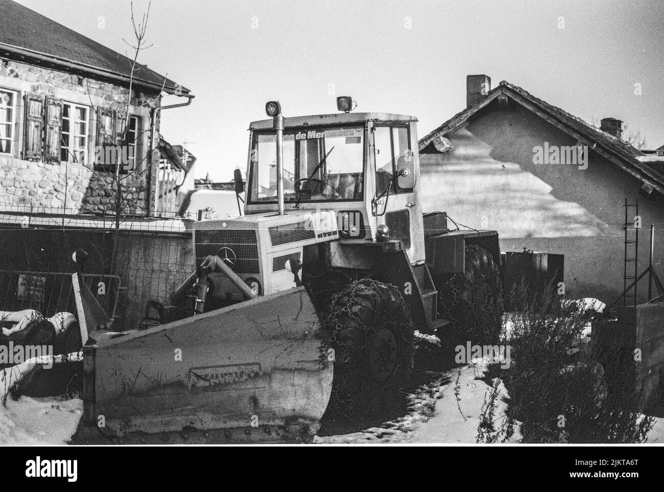 Ancien chasse-neige de tracteur avec chaînes dans les roues. Mercedes Benz Trac 800 Banque D'Images