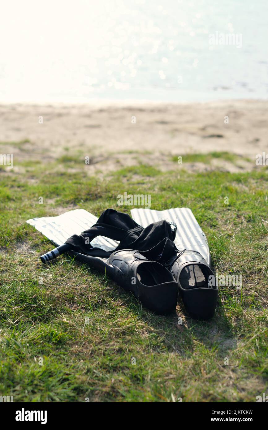 Plan vertical d'une plongée en apnée sur une plage, nageoires de plongée, caleçons de natation, masque de plongée et tuba. Équipement de sports nautiques. Banque D'Images