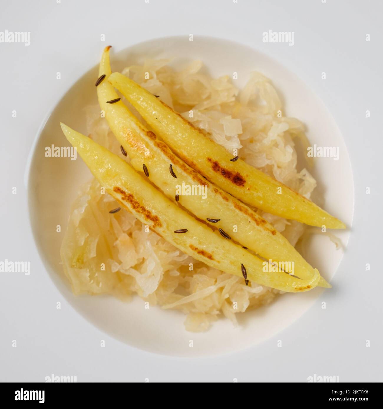 Boulettes de pommes de terre en forme de doigts sur la sauce dans une assiette Banque D'Images