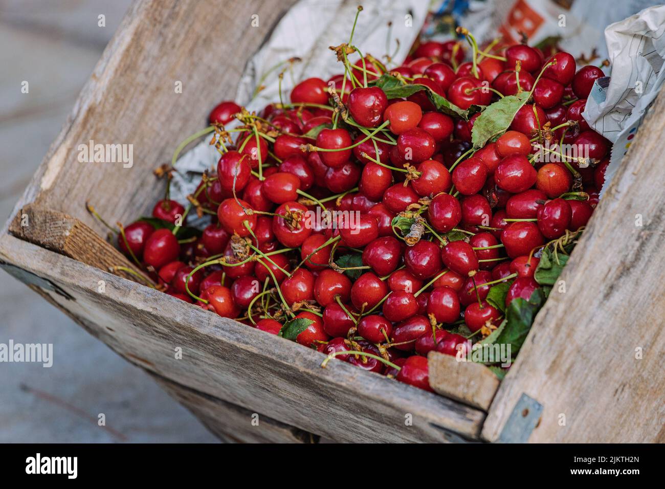 Cerises mûres et sucrées dans un panier en bois au marché de l'agriculteur rustique Banque D'Images
