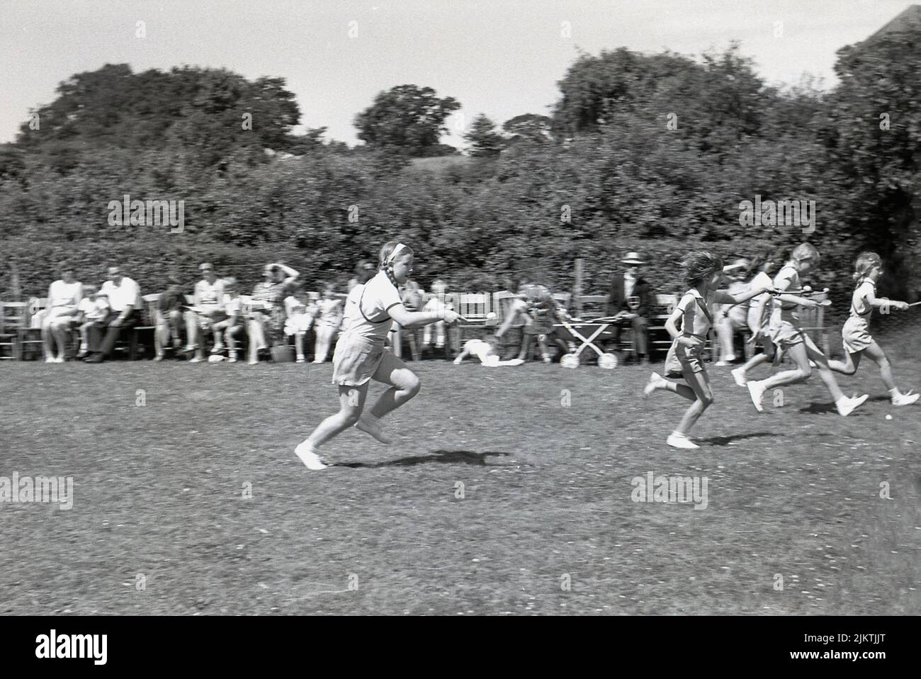 1960, historique, temps d'été et à l'extérieur dans un champ, de jeunes filles en compétition dans une course d'oeuf-et-cuillère, une activité sportive traditionnelle dans les journées de sports primaires, Angleterre, Royaume-Uni Banque D'Images