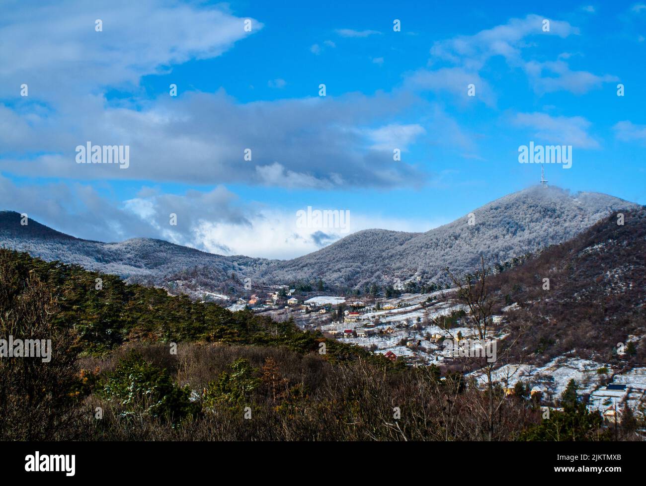 A view of a mountainous area in early spring with small houses scattered around under the blue sky Banque D'Images