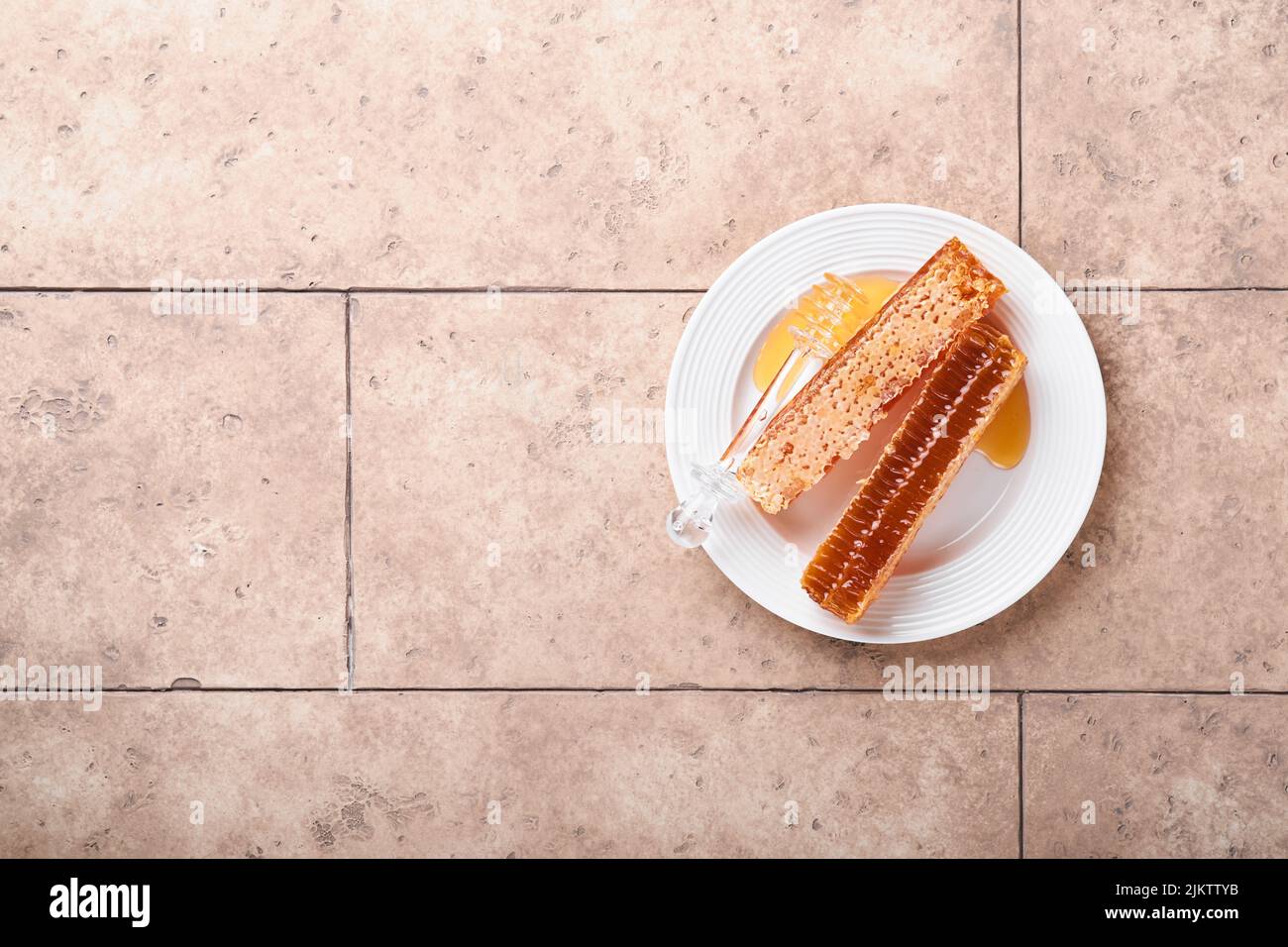 Roch Hachana. Doux nid d'abeilles avec miel, pomme et grenade sur une table en béton rustique beige clair. Fête du nouvel an juif greetin Banque D'Images