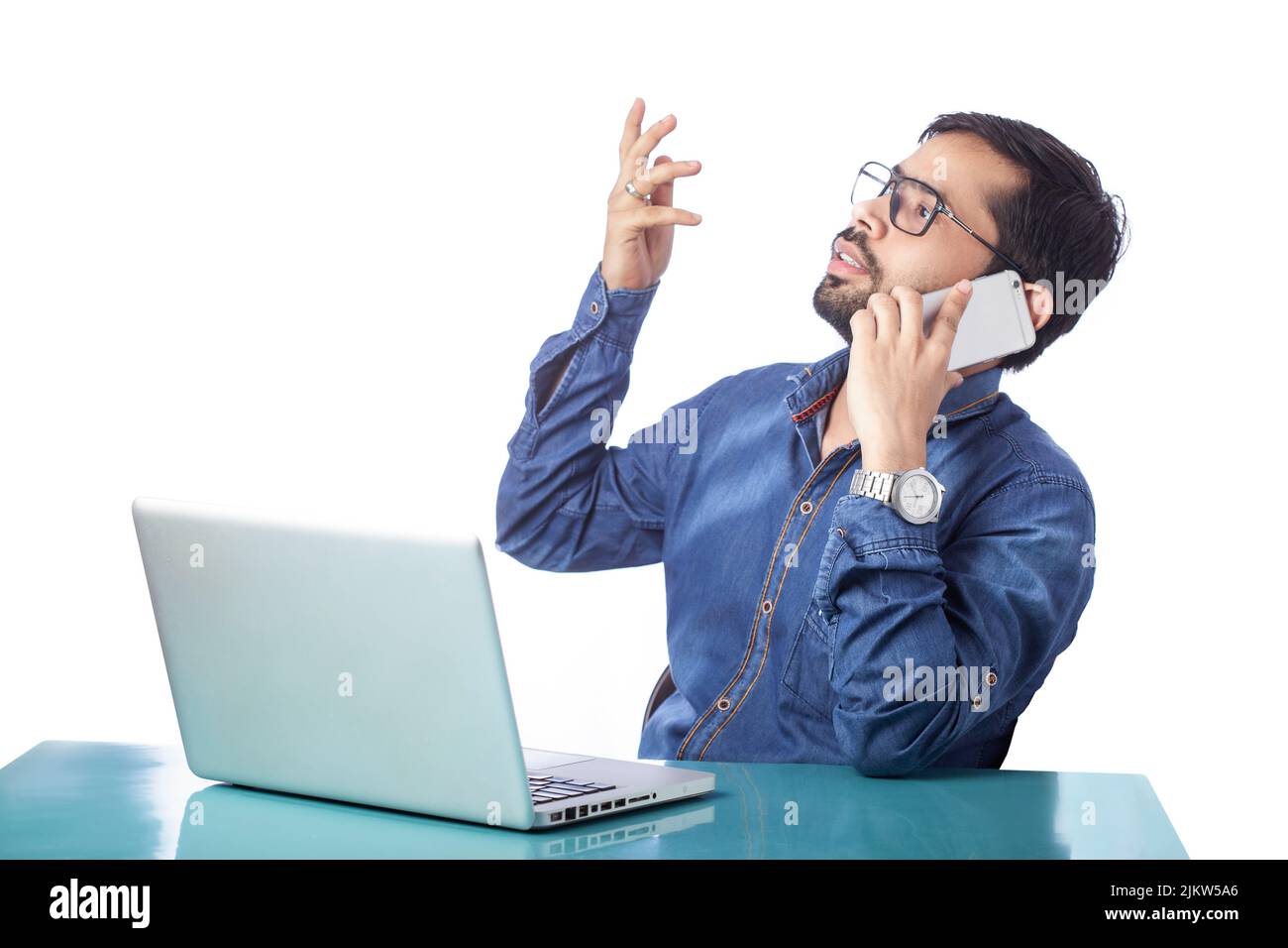 homme d'affaires distrait du travail sur ordinateur portable et parlant sur téléphone portable Banque D'Images