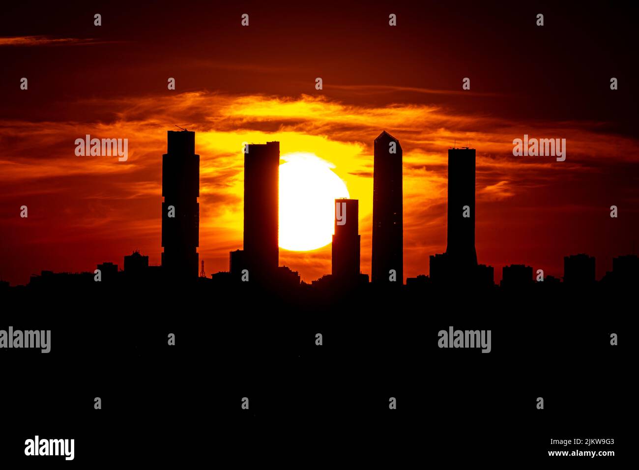 Madrid, Espagne. Mars 2021. Coucher de soleil sur la silhouette des cinq tours du nord de castellana de Madrid et le soleil en arrière-plan entre eux Banque D'Images