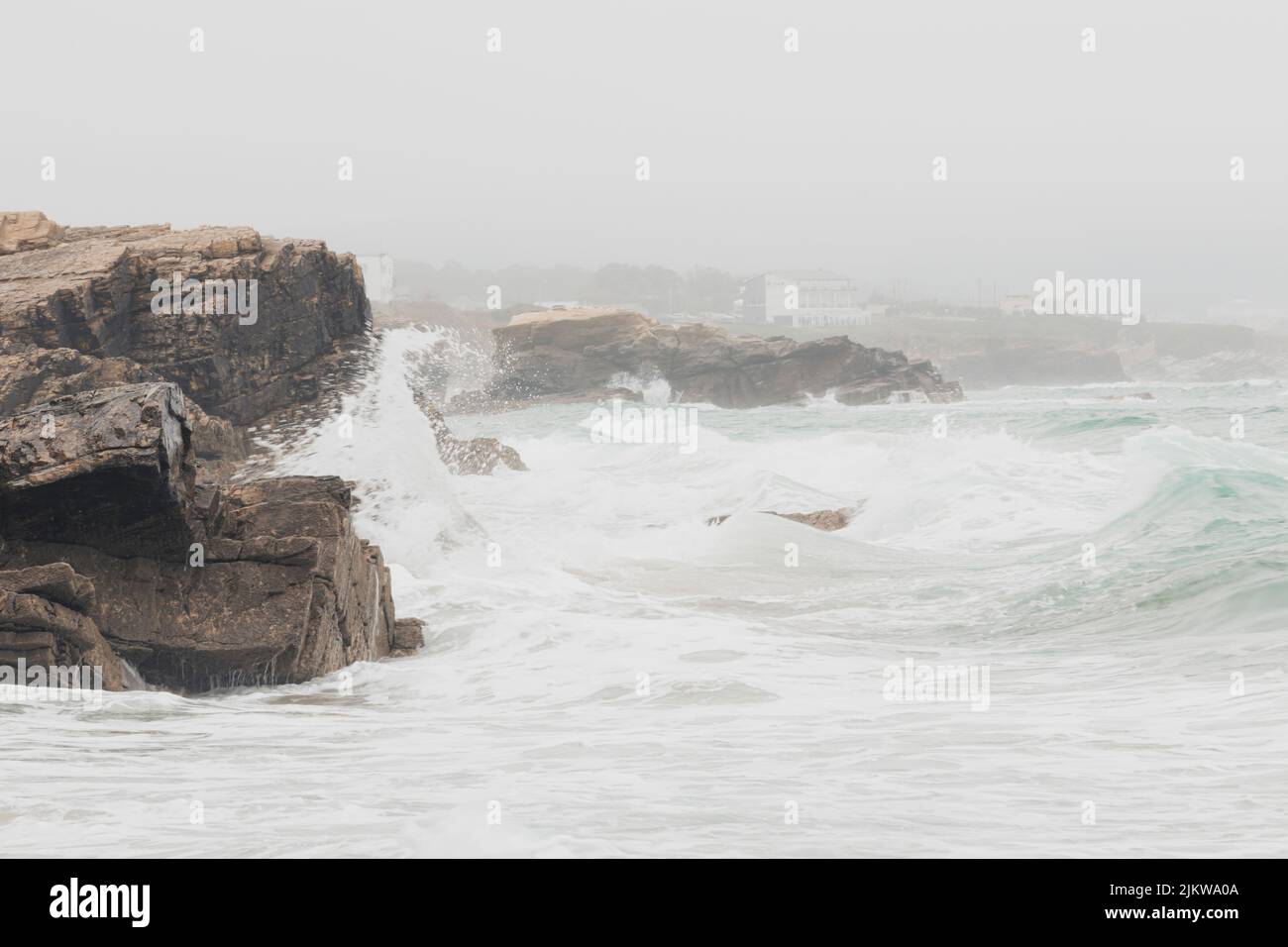 Falaises situées à côté de la plage de Punta Corveira à Lugo, Espagne, pendant une journée de pluie avec de fortes vagues. Banque D'Images