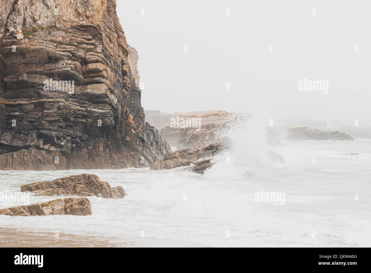 Falaises situées à côté de la plage de Punta Corveira à Lugo, Espagne, pendant une journée de pluie avec de fortes vagues. Banque D'Images