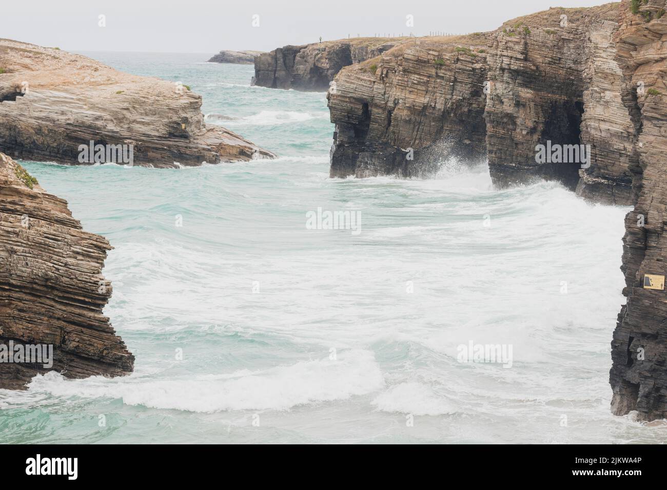 Falaises situées dans la plage touristique des cathédrales à Lugo, en Espagne, pendant une journée de pluie, avec des vagues et une marée haute. Banque D'Images