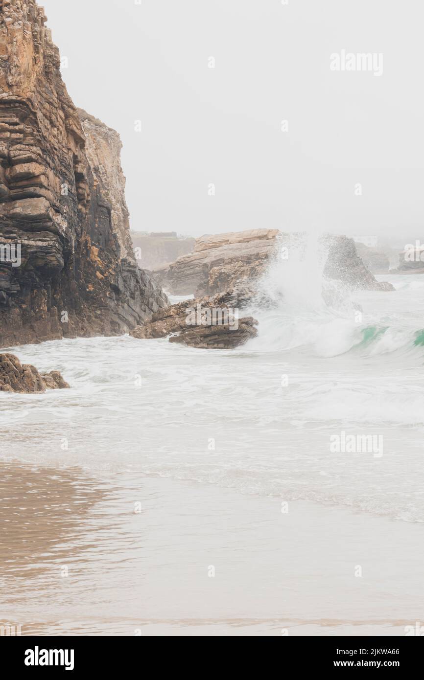 Falaises situées à côté de la plage de Punta Corveira à Lugo, Espagne, pendant une journée de pluie avec de fortes vagues. Banque D'Images