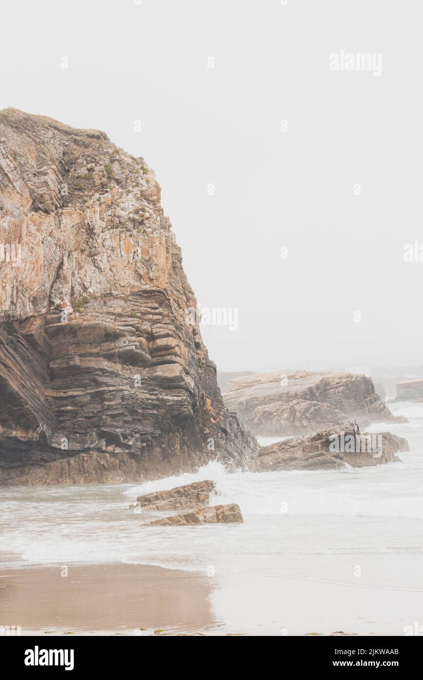 Falaises situées à côté de la plage de Punta Corveira à Lugo, Espagne, pendant une journée de pluie avec de fortes vagues. Banque D'Images