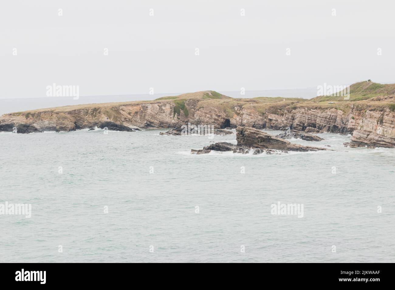 Falaises situées à côté de la plage de Punta Corveira à Lugo, Espagne, pendant une journée de pluie avec de fortes vagues. Banque D'Images