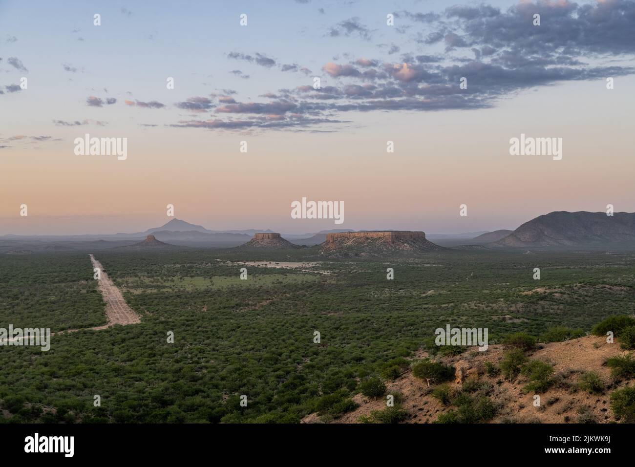 Namibie, paysage à Damaraland, avec de grands rochers et une route de terre au coucher du soleil Banque D'Images