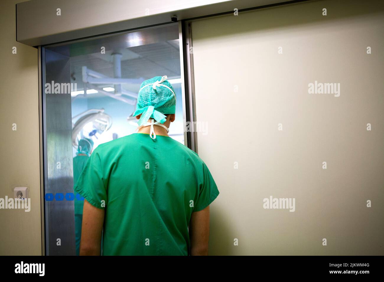 Chirurgie orthopédique, une infirmière étudiante observe la progression d'une opération à l'extérieur de la salle d'opération. Banque D'Images