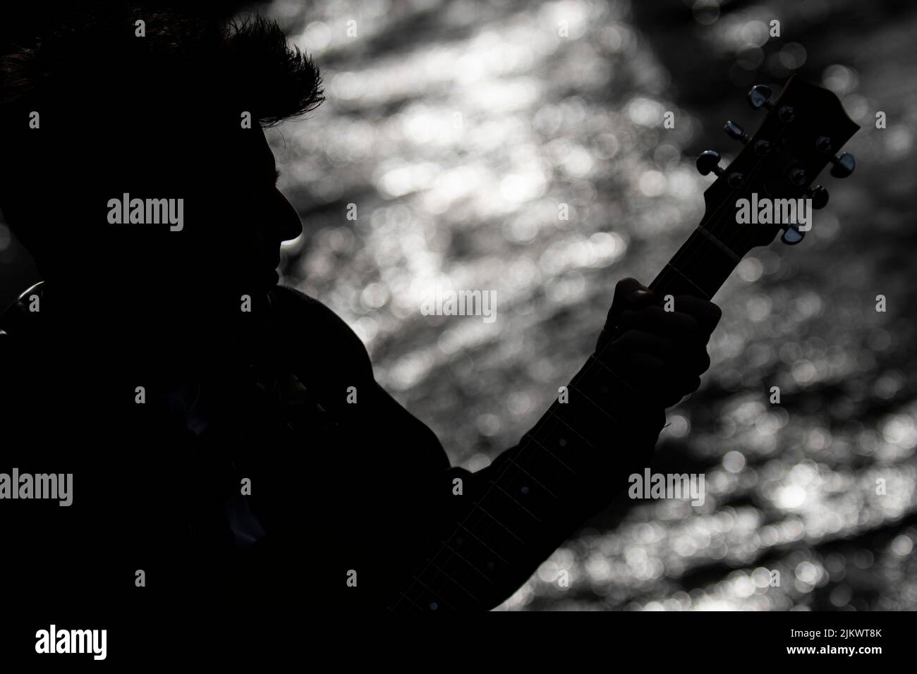 silhouette d'un garçon avec une guitare sur la rive Banque D'Images