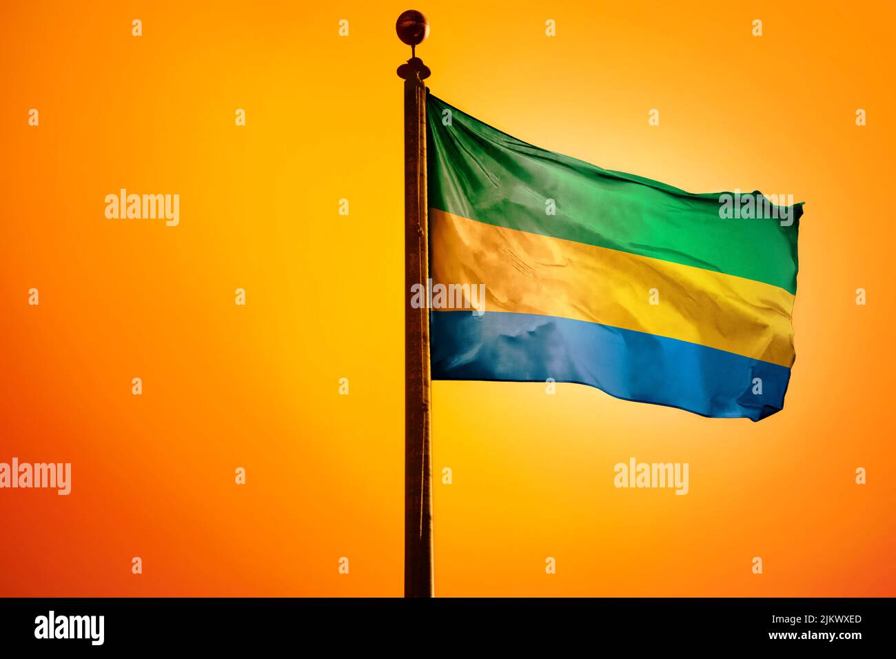 Une illustration numérique du drapeau du Gabon qui agite contre un ciel jaune vif Banque D'Images