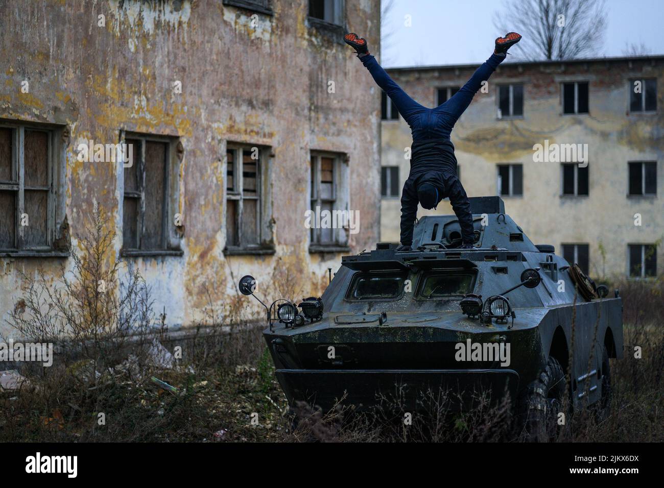 Homme faisant une main sur un char BTR dans la cour d'une caserne soviétique abandonnée Banque D'Images