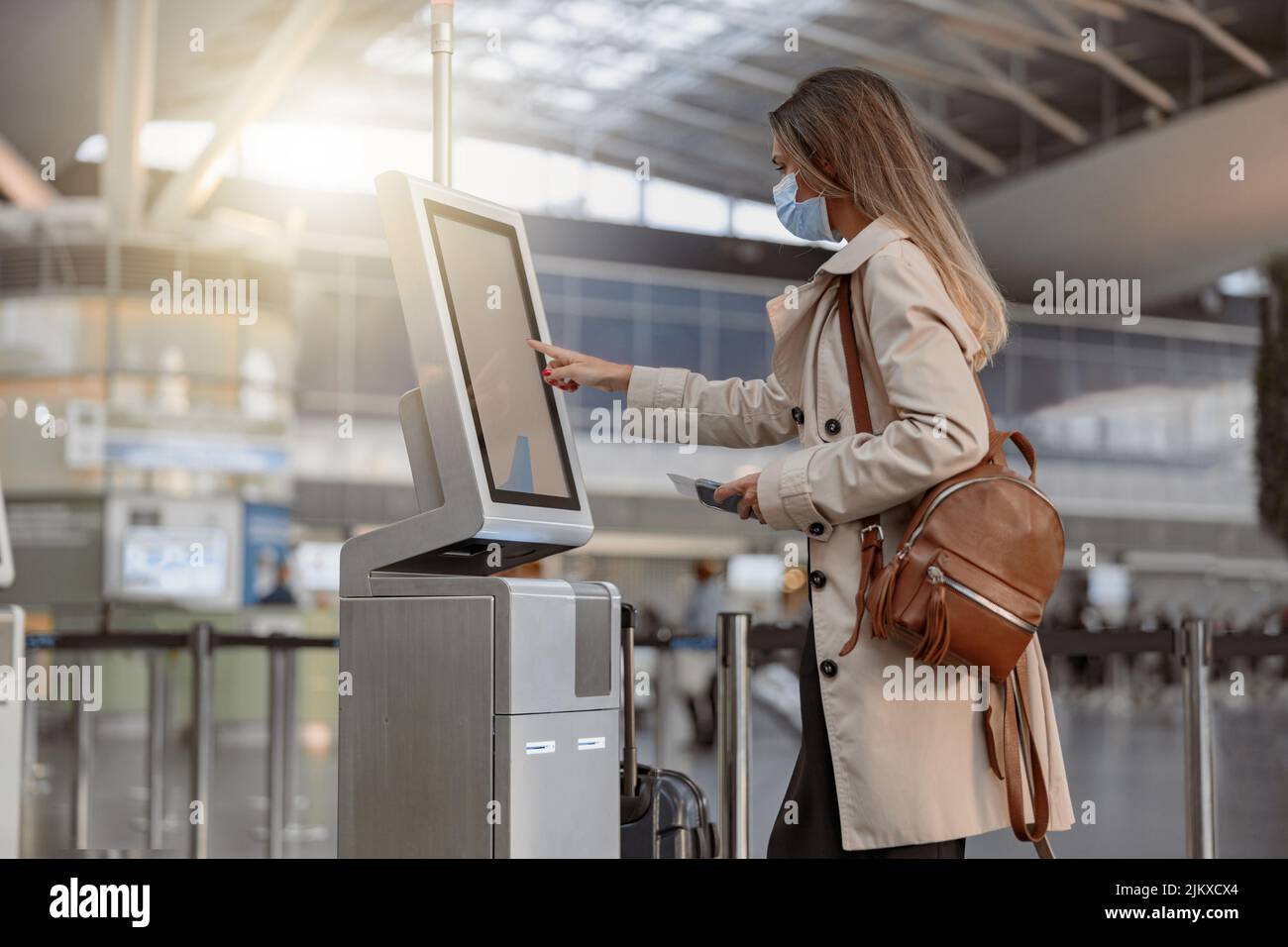 Jeune femme debout et utilisant des médias numériques vierges à l'aéroport Banque D'Images