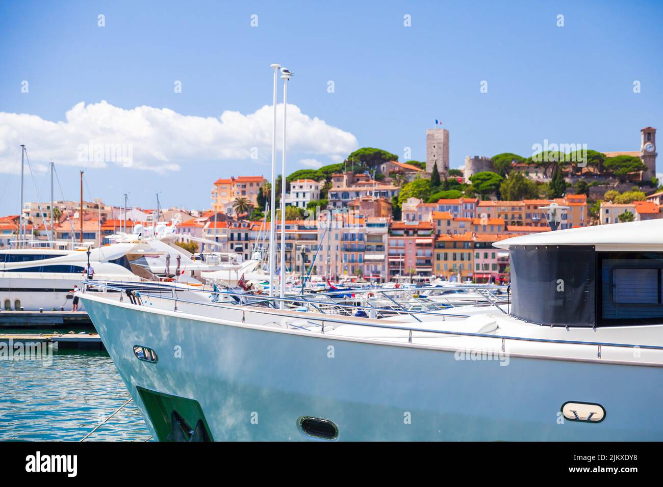 Vue sur le port de plaisance de Cannes par une belle journée d'été, yachts amarrés et maisons colorées en arrière-plan. France Banque D'Images