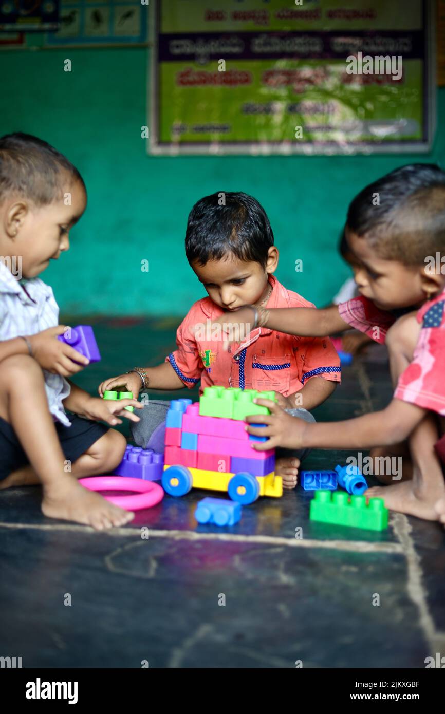 Un foyer sélectif de visage d'un petit village indien du sud jouant avec des blocs de construction dans une école maternelle (également appelé Anganwadi en Inde). Banque D'Images