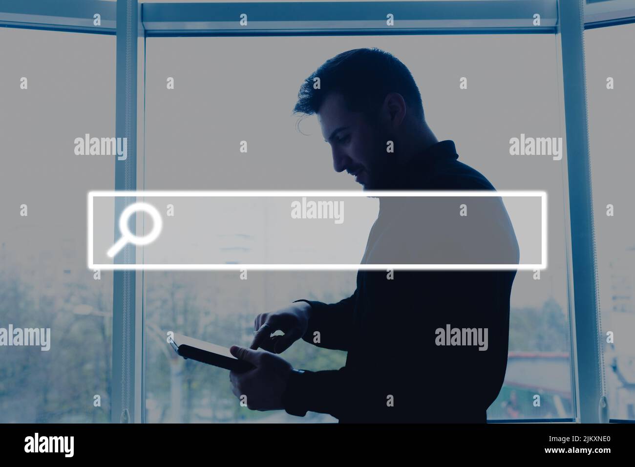 Jeune homme travaillant sur un ordinateur portable au bureau avec un bouton de recherche d'écran visuel Banque D'Images