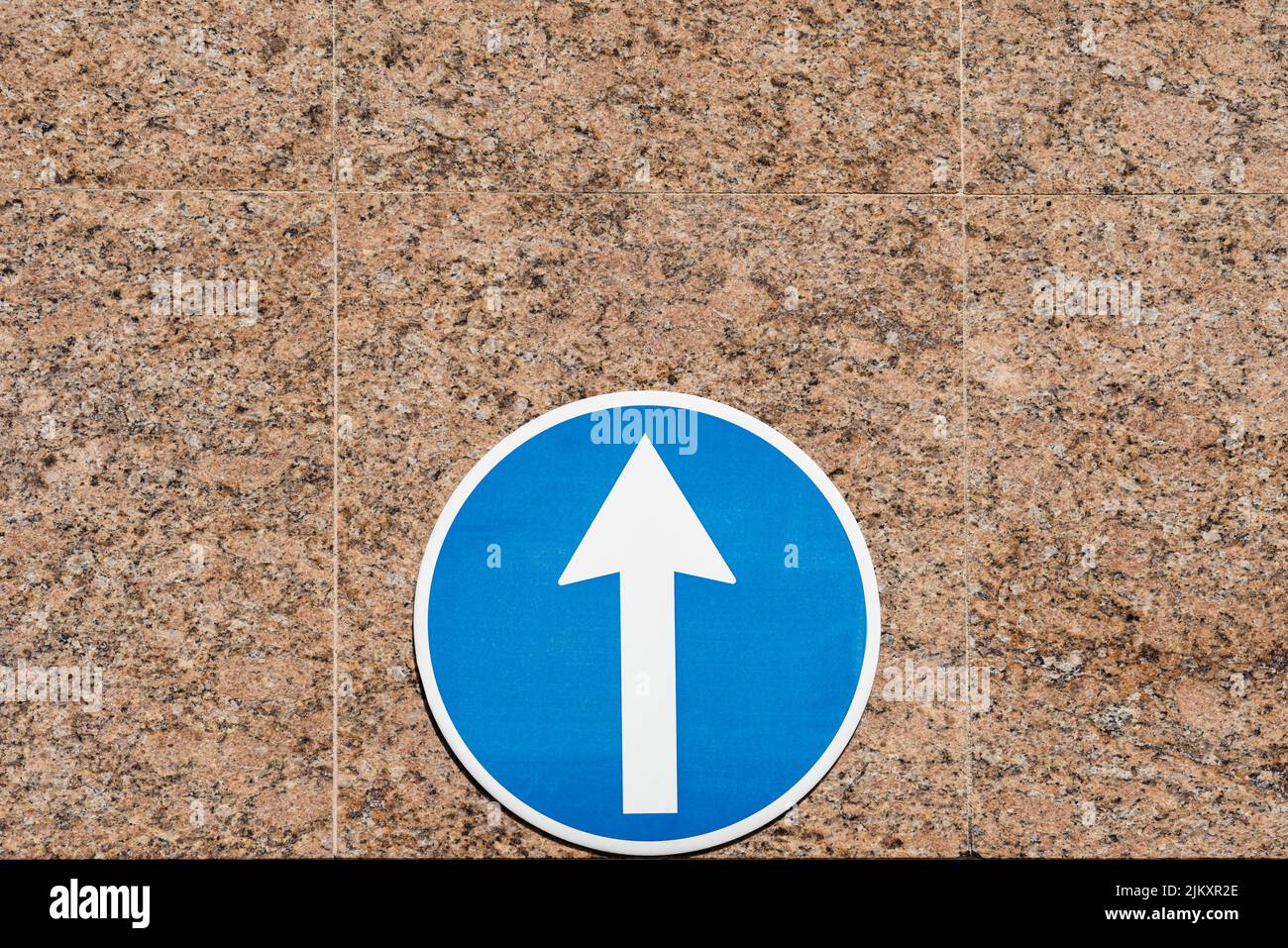 Un gros plan d'un panneau de signalisation bleu à sens unique affiché sur le mur Banque D'Images