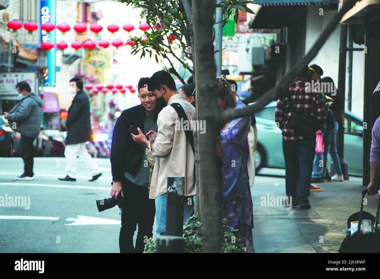 Une belle photo de deux amis asiatiques regardant quelque chose ensemble sur le mobile pendant la journée à Chinatown, San Francisco, Californie, États-Unis Banque D'Images