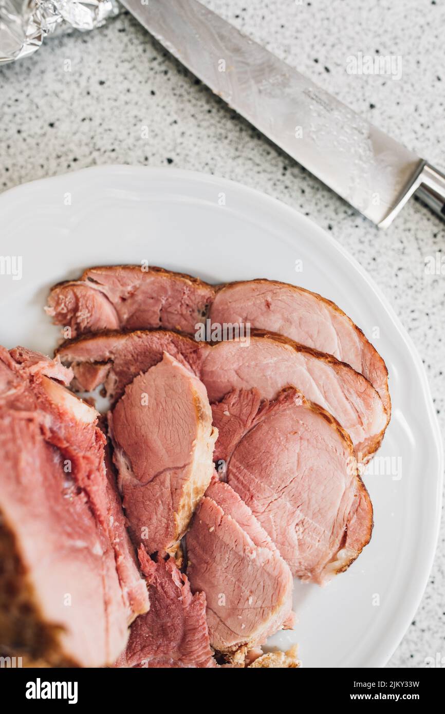 émincé de viande de jambon en os Kurobuta sur le comptoir de cuisine avec couteau Banque D'Images