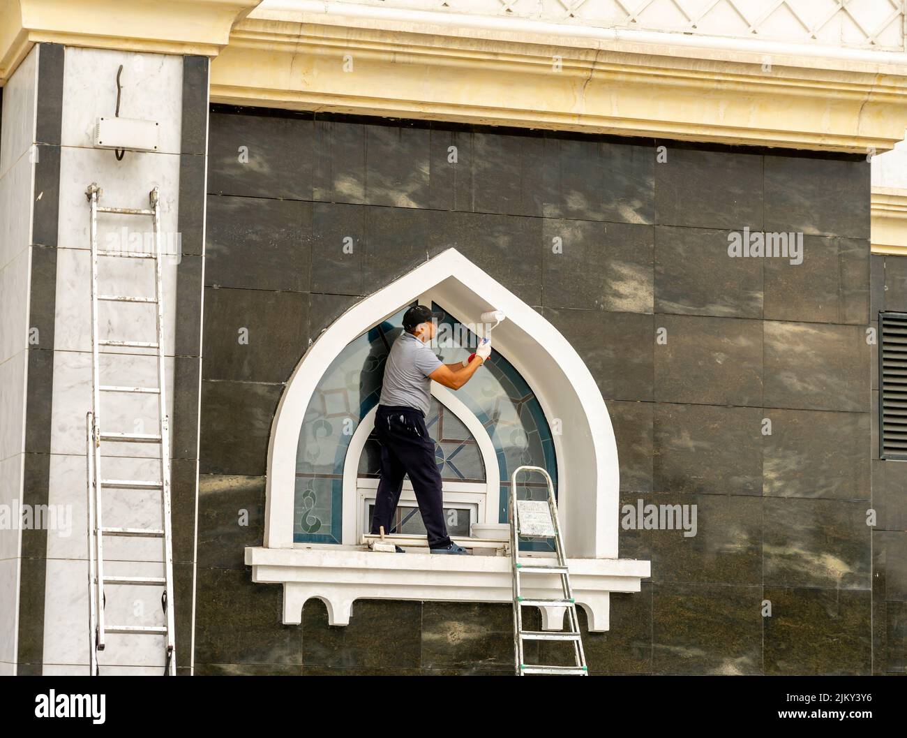 Un peintre peint un bâtiment de conception kazakh traditionnelle. Nur-Sultan, Astana, Kazakhstan Banque D'Images