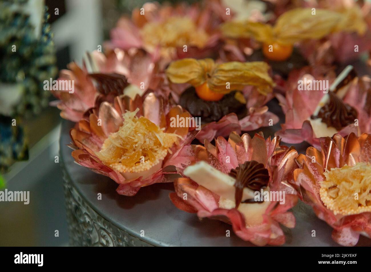 Un cliché sélectif de friandises sucrées dans des papiers à motif pétales de fleurs roses Banque D'Images