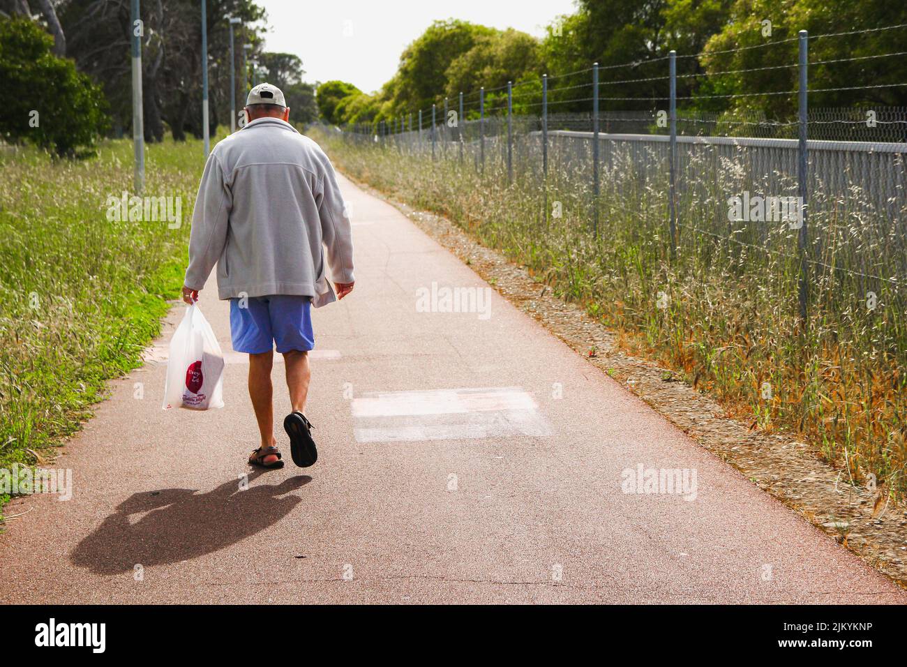 Un homme marchant sur un trottoir pendant chaque tâche de la vie quotidienne Banque D'Images