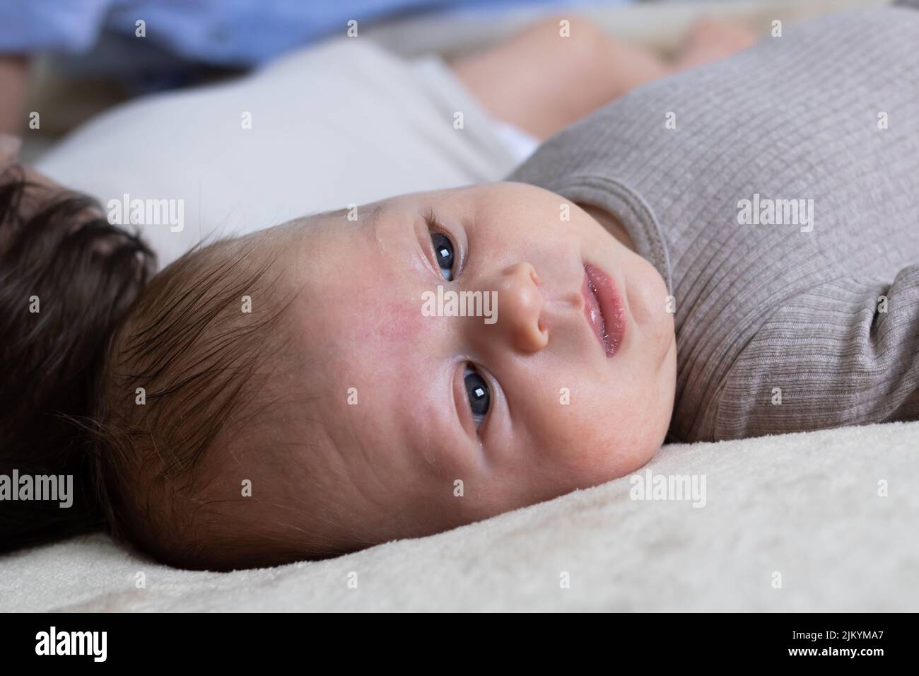 Un gros plan d'un bébé nouveau-né mignon allongé sur une couverture blanche Banque D'Images