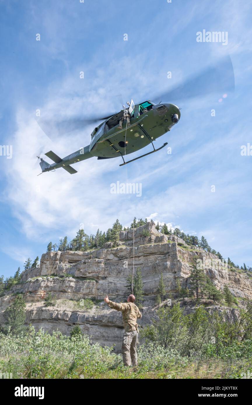 Sergent d'état-major Joel Hogan, mécanicien de bord instructeur des missions spéciales du 40th e Escadron d'hélicoptères, détient une ligne d'étiquettes menant à un hélicoptère UH-N1 Huey le 2 août 2022, dans le parc national Sluice Boxes, au Mont. En plus des opérations de recherche et de sauvetage, le 40th HS assure une sécurité stratégique en fournissant des Support de transport aérien d'hélicoptère à réponse rapide à l'aile missile 341st. (É.-U. Photo de la Force aérienne par Heather Heiney) Banque D'Images