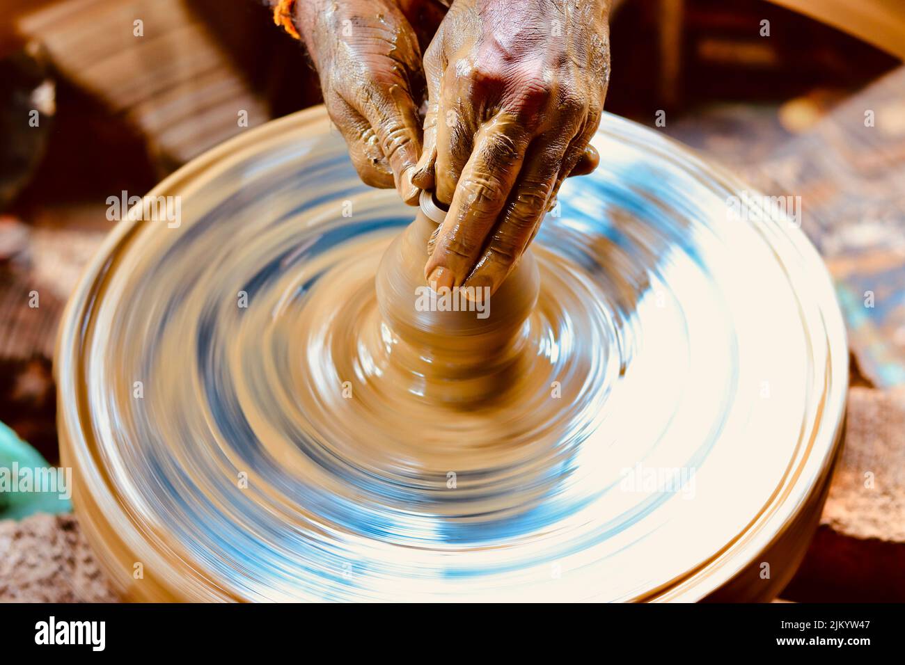 Photo à vitesse d'obturation lente d'une main de potier faisant un pot à partir d'une roue de poterie. Banque D'Images