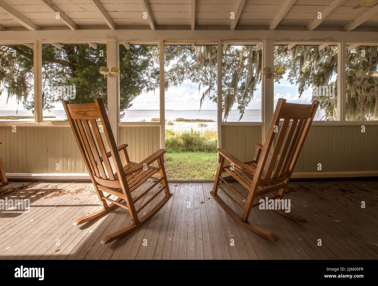 Une paire de vieux fauteuils à bascule sur un porche donnant sur une entrée à l'île de Sapelo, Géorgie Banque D'Images