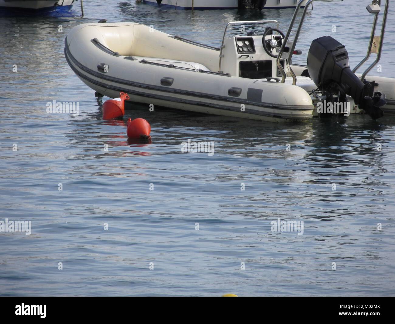 Seul canot pneumatique avec moteur hors-bord se trouve à l'ancre dans un port . La toscane, italie Banque D'Images