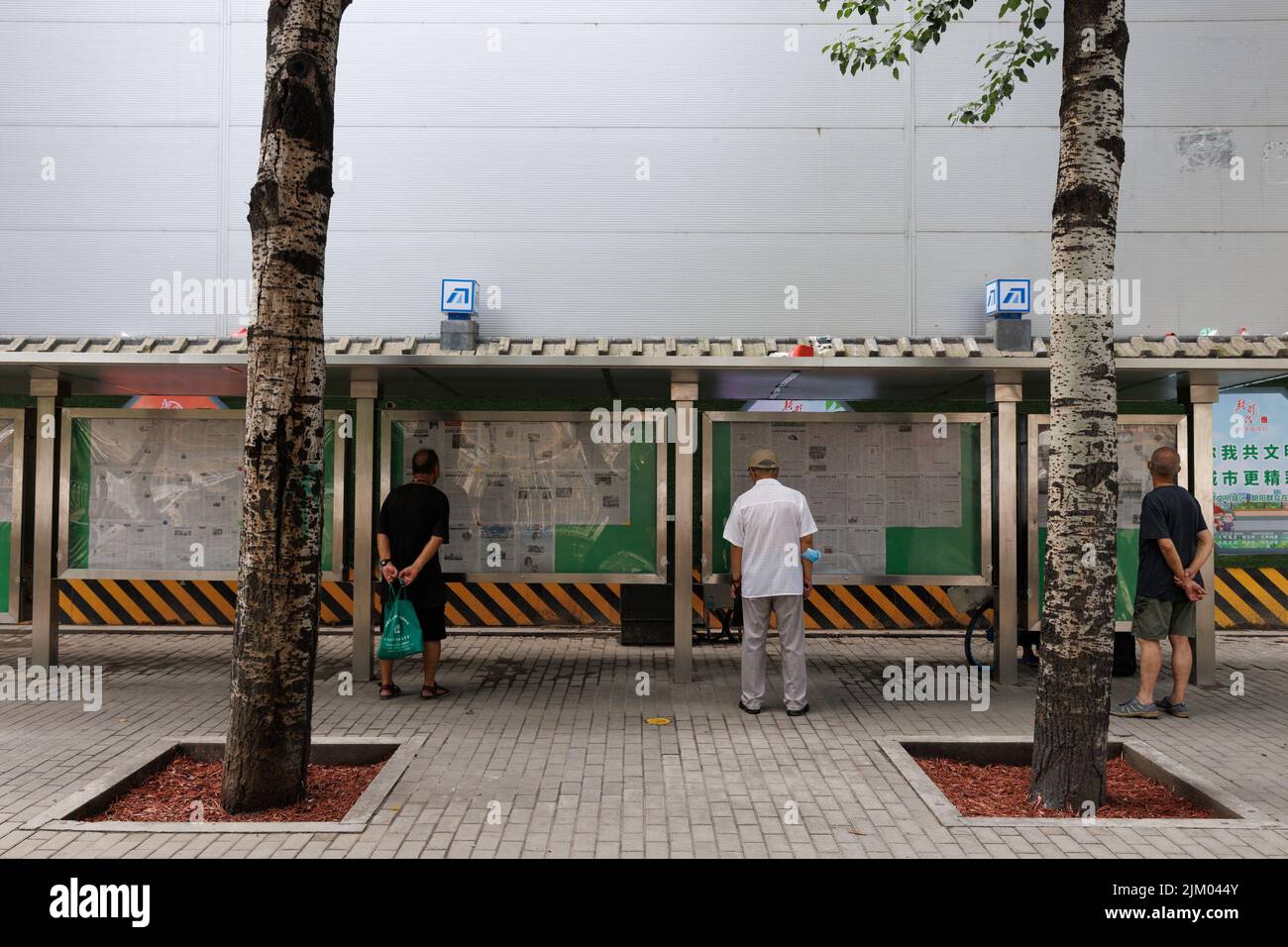 Les hommes lisent les journaux de la journée dans un kiosque à Pékin, en Chine, au 4 août 2022. REUTERS/Thomas Peter Banque D'Images