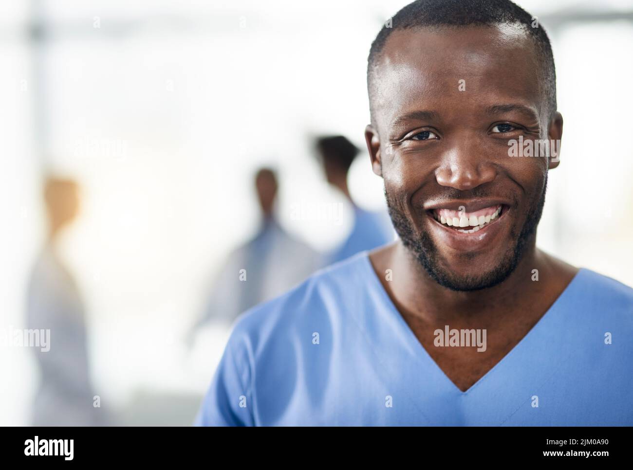 Médecin souriant et professionnel dans un portrait de gros plan à l'hôpital avec un arrière-plan flou. Professionnel de la santé homme noir confiant avec Banque D'Images