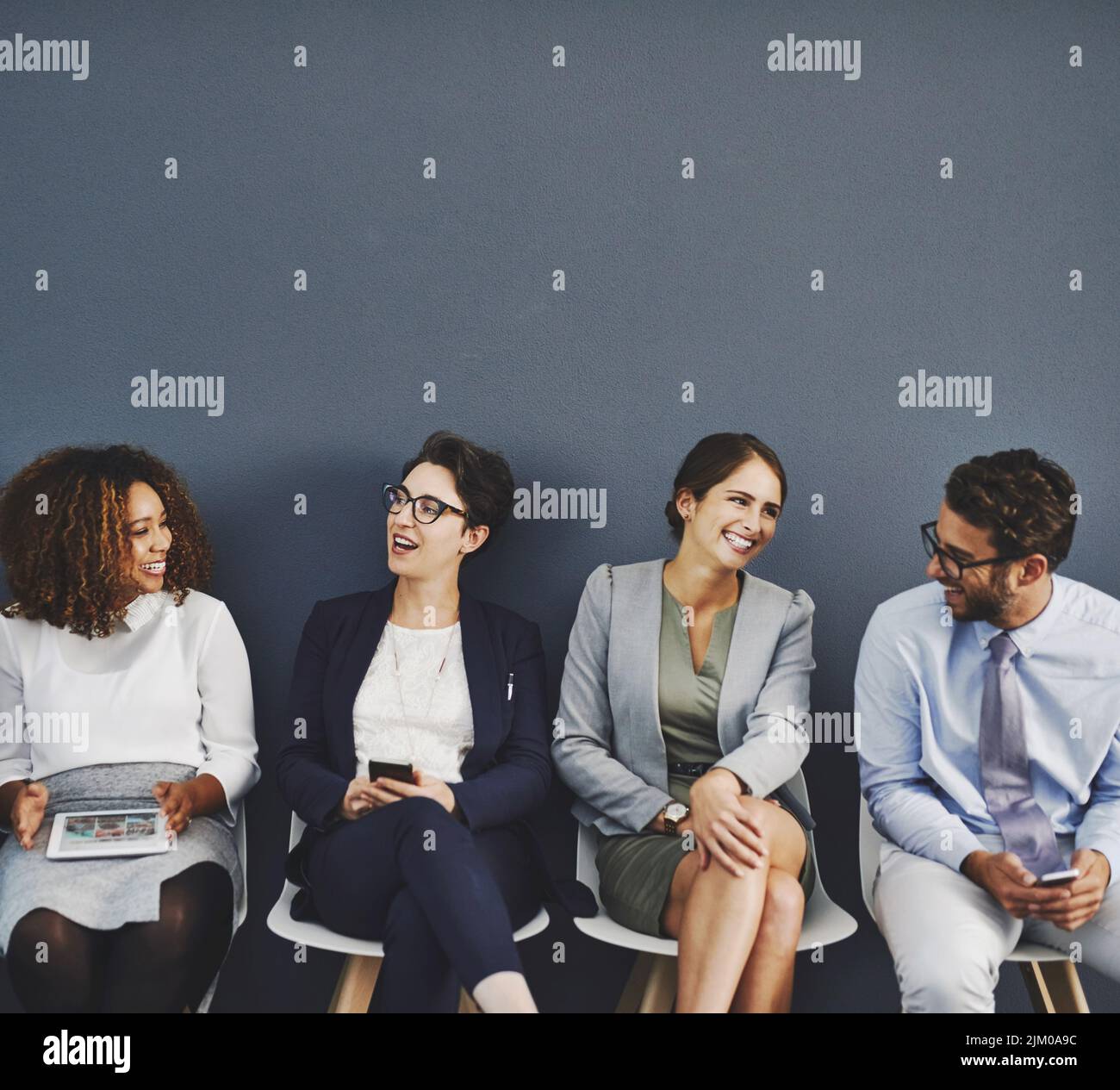 Attente d'un entretien, connecté, communication et réseau de divers hommes d'affaires utilisant la technologie multimédia. Heureux groupe professionnel assis Banque D'Images