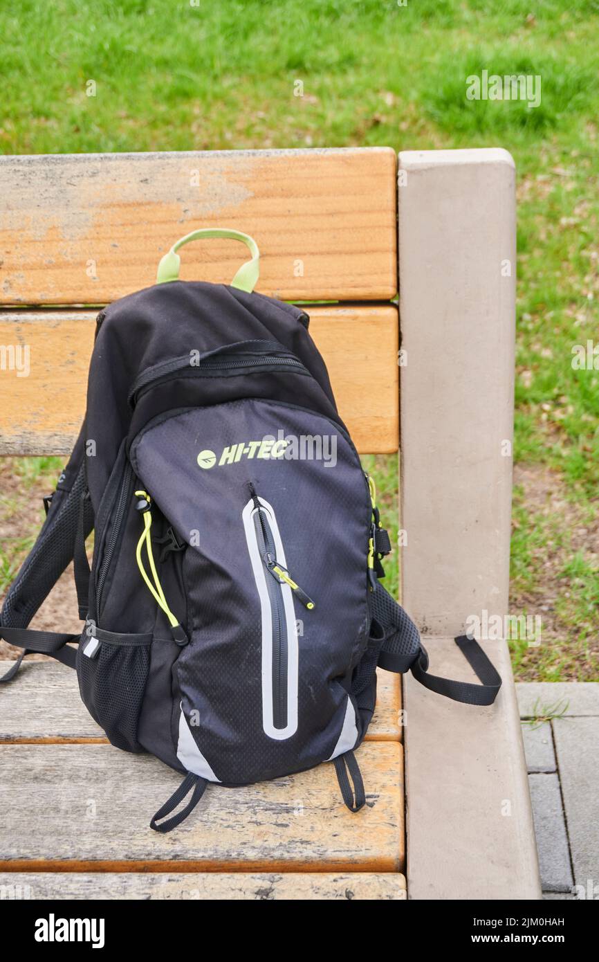Une photo verticale d'un sac à dos de marque Hi TEC sur un banc de parc en bois. Banque D'Images